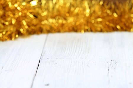 Christmas golden chain  on white wooden table Christmas chain  on board, good for backgroundの写真素材