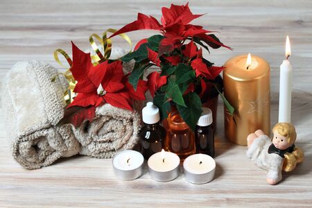 Wellness objects,  plant  Euphorbia pulcherrima, towels and essential oil  on the wood table.の写真素材