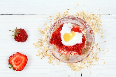 Face mask from strawberry, yogurt, oatmeal  and honey. Edible ingredients for facial mask on the white wooden board, flat layの写真素材