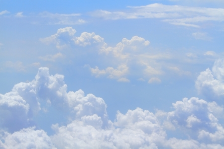 Skyline view from an airplane on the nice blue sky. Sky with curly nice clouds in daytime