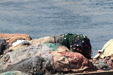  Fishing tackle on the boat, nets and floats. Detail of  fishing equipment and the sea behind.