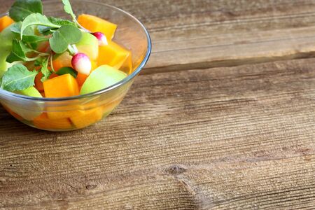 Fermented salad from butternut and green apple with dressing. Vegetarian fermented salad decorated with young radish, copy spaceの写真素材