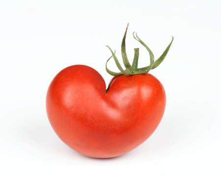 Tomato in shape of heart. Naturally grown tomato on the white background.の写真素材