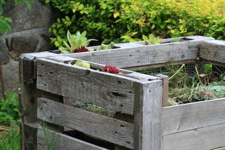 Detail of composter with organic waste from pallets. Reusable concept. Frame decorated with cobweb...