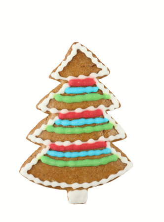 Christmas gingerbread tree. Homemade gingerbread in a shape of Christmas tree decorated by child. White background, flat lay.の写真素材