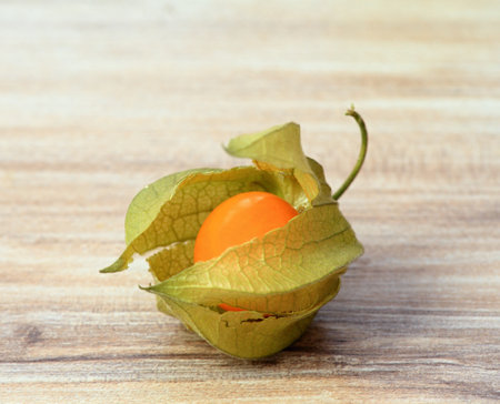 Ripe fruit of Physalis peruviana with husk on wooden table. Also known as cape gooseberry, ground cherries or winter cherry.の写真素材