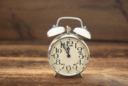Vintage alarm clock. Old alarm clock on brown wood table.