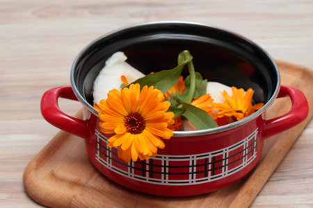 Making organic calendula cream for healthy skin. Homemade preparation of organic medicinal ointment from marigold flower heads and lard.の写真素材