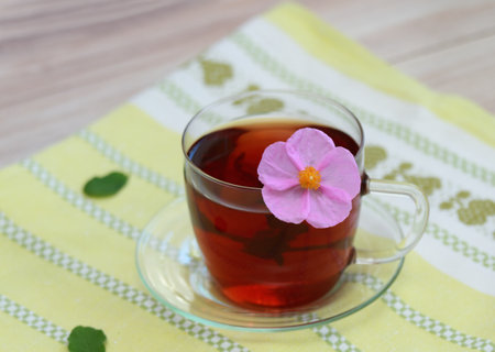 Cup of herbal infusion from Cistus incanus, known as rock rose. Traditional herbal tea with many external and internal benefits. Beautiful pink rock rose flower in tea.の写真素材