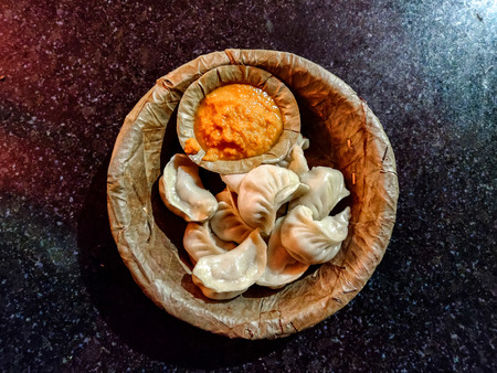 Steam momo served in a leaf plate with plastic forkの写真素材