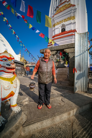 Kathmandu, Nepal - November 4 2018: A happy old man holding scented incense stick at Swayambhunath Stupaのeditorial素材