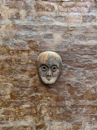 Wooden mask hanging on a wallの写真素材
