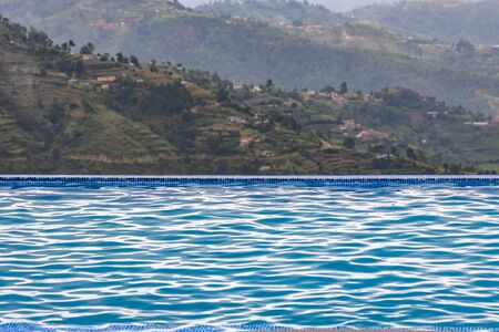 Infinity swimming pool with hills in the background