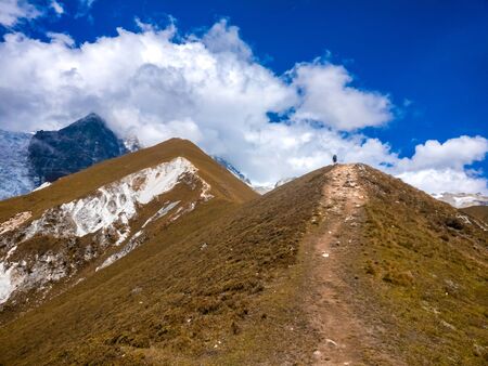 Guy hiking towards Upper Kyanjin Ri peak (4800 m.) in Langtang National Park, Nepal.