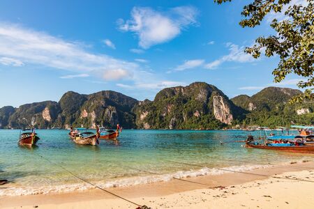 traditional wooden longtail boats parked at a beach in Phi Phi Island. Clear water and clean beach.の写真素材