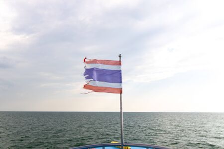 Flag of Thailand waving in the front of a ferry ship sailing in Andaman Sea.の写真素材
