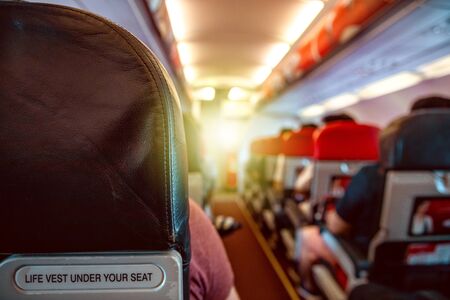 Interior of an airplane with passengers on seats waiting for takeoff.の写真素材