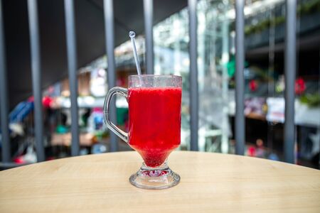 A glass full of blueberry juice placed on a wooden surface.の写真素材