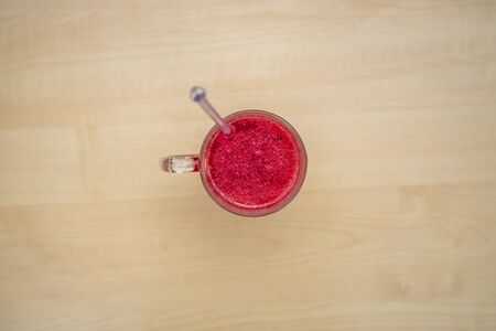 A glass full of blueberry juice placed on a wooden surface.の写真素材
