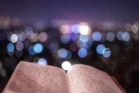 A journal notecopy placed outdoors at an evening against defocused lights of the city. writing blogging student concept. selective focusの写真素材