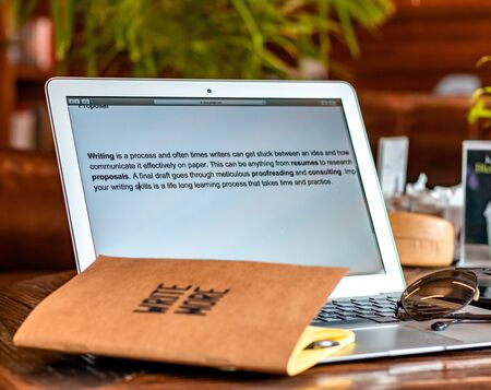 Blogger concept. There is a pc laptop with notebook and pen at a table in a cafe. selective focus