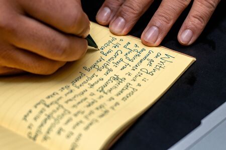 Hand of a young businessman taking notes with a fountain pen on a notecopy.  Student learning online. Blogger. selective focusの写真素材