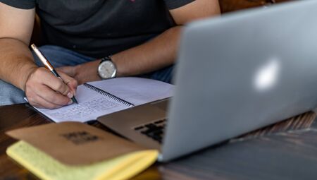 Hand of a young businessman taking notes with a fountain pen on a notecopy.  Student learning...