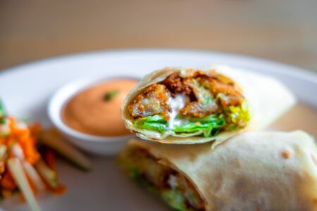 Vegetable Fillings Rolled inside an Indian Bread served on a White Plate with Mayoonaise Sauce