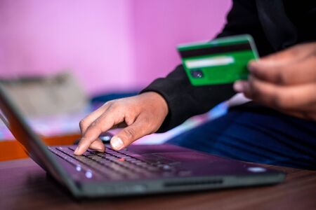 Hands holding credit card and using laptop. Online shopping concept. Using Credit Card for online...