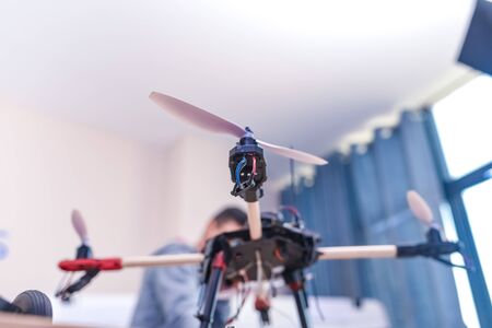 Closeup programmer hands making electronic FPV - first person view drone at home office. Developer...