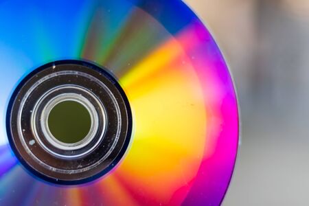 Compact Disc. Holding a CD in hands. The back side of the CD reflects colorful lights. Rainbow colors.の写真素材