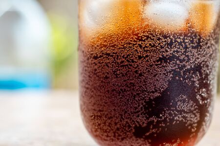 Close up Glass filled with carbonated cola soft drink with ice cubes. selective focusの写真素材