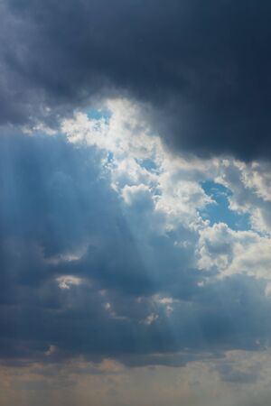 Heavenly Sun Rays Through Dark Clouds Against The Blue Sky. selective focusの写真素材