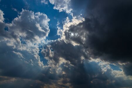 Heavenly Sun Rays Through Dark Clouds Against The Blue Sky. selective focusの写真素材