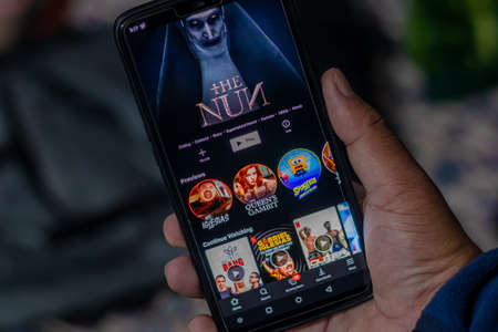 Kathmandu, Nepal - November 7 2020: Hands using YouTube app on android phone indoors.のeditorial素材
