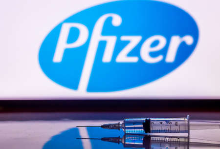 Kathmandu, Nepal - November 24 2020: Syringe Injection infront of Pfizer Logo. Pfizer and...