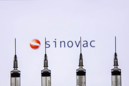 Kathmandu, Nepal - January 03 2021: Closeup of a syringe against Sinovac logoのeditorial素材