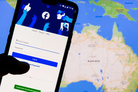 Kathmandu, Nepal - February 18 2021: Smartphone with Facebook's login screen against the maps of...