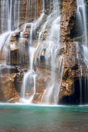 Smooth Long Exposure of Waterfall. Creamy Beautiful waterfall falling off a cliff in the mountas.