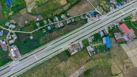 Aerial view of six-lane highway passing through meadows, fields and scattered houses towards...