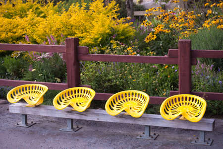 A shot of tractor seats bolted on a benchの写真素材