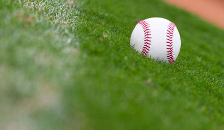 A close up of a baseball sitting just inside the right field foul line.の写真素材