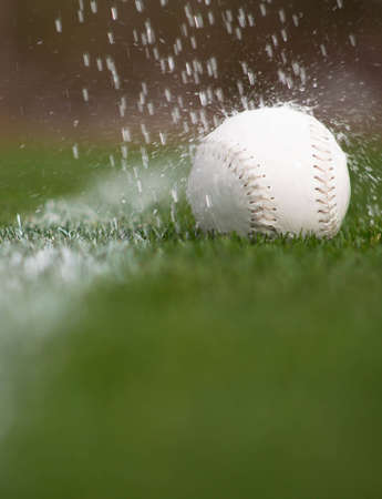 A close up of a softball caught in a sprinkler.