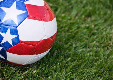 A close up of a stars and stripes soccer ball on grass.の写真素材