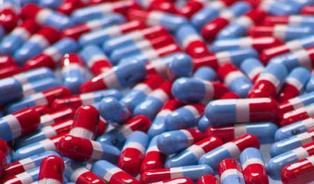 A close up of a bunch of red, gray and blue pills.の写真素材