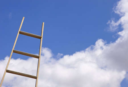A close up of a gold ladder sticking up into a blue sky.の写真素材
