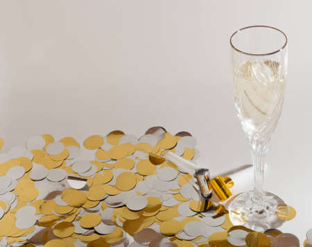 A close up of a glass of champagne surrounded by confetti.の写真素材