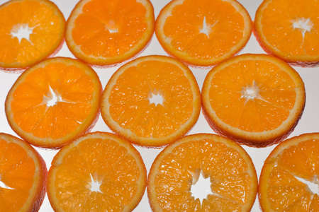 A close up of a cross section of a bunch of Tangerine fruit with a white background.の写真素材