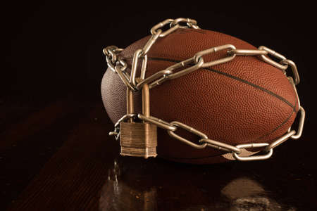 A close up of a football locked up with chain.の写真素材