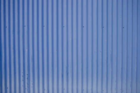 A close up of an old blue steel warehouse wall.の写真素材